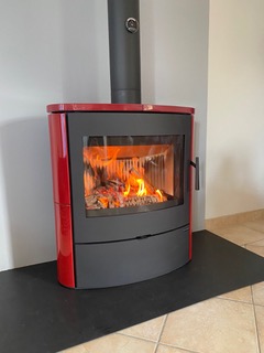 Installation d'un poêle à bois Navia en céramique rouge
