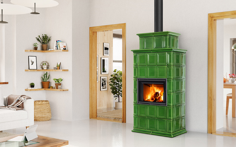 Poêle à bois à accumulation BARACCA en céramique verte, diffusant une chaleur douce et durable par rayonnement dans un intérieur contemporain.