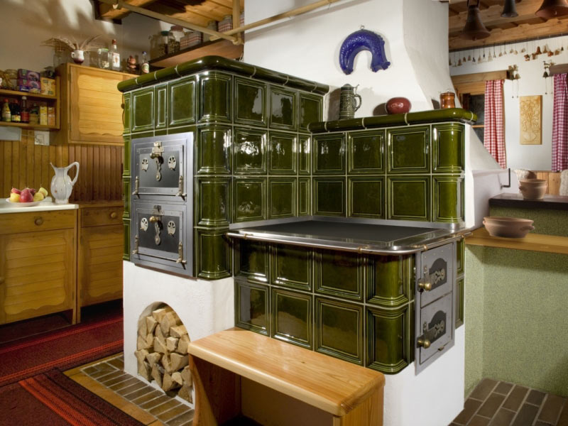 Poêle cheminée en céramique verte avec cuisinière bois intégrée, réalisation sur mesure par ROMOTOP